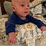 Braxlee joined the competition — help win amazing prizes! baby, infant, child, blue_clothing, pillow, animal_pattern, face, eyes, hand, wooden_wall, blanket, indoor, person, cute, young, portrait, soft_lighting, expression, home, comfort
