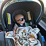 baby, car_seat, sunglasses, blanket, infant, car_interior, seat_belt, child, child_safety, seat, comfort, travel, shade, head_support, window, sunlight, relaxation, cute, protection, rest