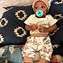 baby, pacifier, cushion, patterned_clothing, hat, infant, blanket, socks, cute, indoor, person, child, fabric, animal_print, comfort, resting, soft_toys, home, portrait, relax