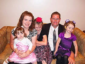 Taylor is registered to the contest to win money with this photo: child, dress, event, family, formal_wear, fun, joy, party, people, person, sitting, smile, toddler