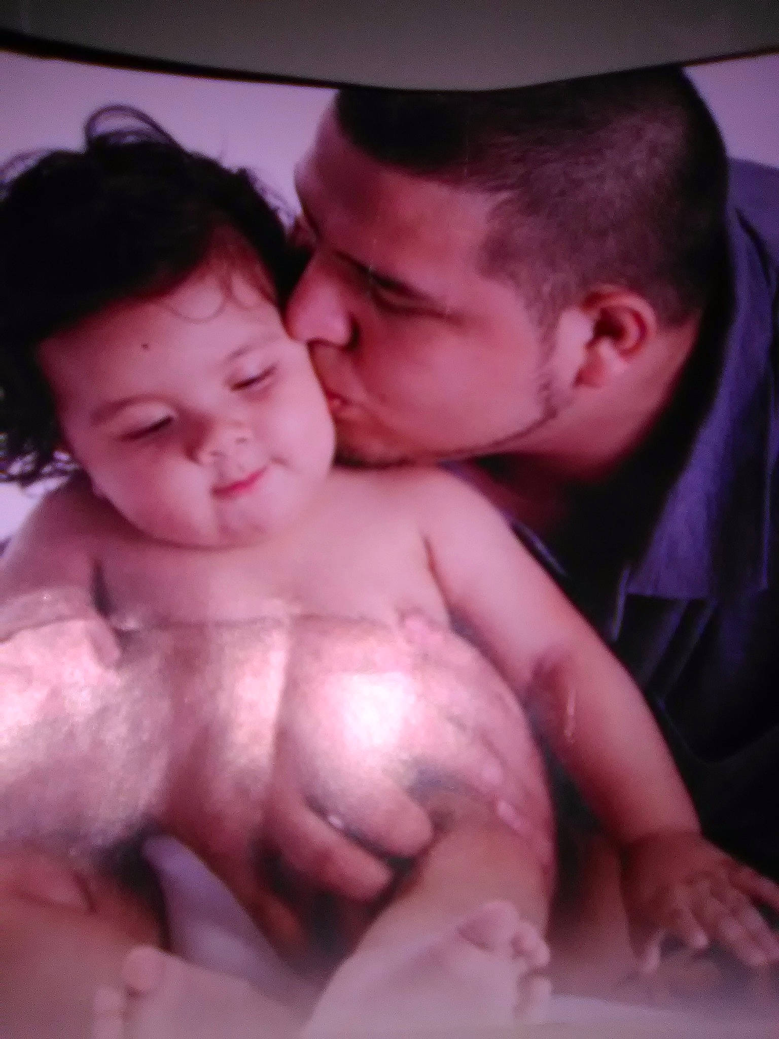 Michael is registered to the contest to win money with this photo: baby, barechested, black_hair, cheek, child, flesh, fun, gesture, human, interaction, love, mouth, muscle, person, smile, thumb