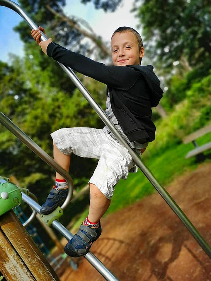 Lorenzo a rejoint le concours — aidez-le/la à gagner de superbes lots ! adventure, balance, city, fun, grass, happy, joy, leisure, outdoor_play_equipment, people_in_nature, person, plant, playground, recreation, rope, shorts, sky, smile, swing, t_shirt