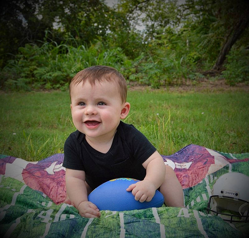 Easton is registered to the contest to win money with this photo: baby, baby_toddler_clothing, cool, eye, fun, grass, grass_family, happy, head, joy, lawn, leisure, meadow, people_in_nature, person, plant, recreation, sitting, smile, t_shirt