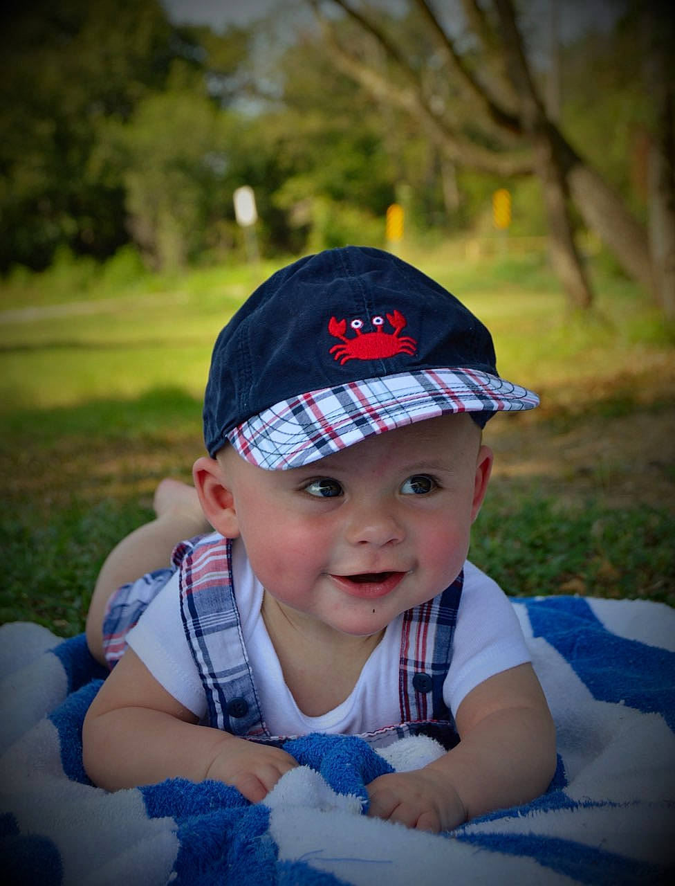 Easton is registered to the contest to win money with this photo: baby, baby_toddler_clothing, baseball_cap, cap, child, cool, electric_blue, flash_photography, grass, happy, hat, headgear, headwear, joy, lip, pattern, person, plant, recreation, smile