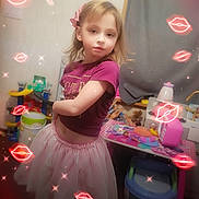 Kennedy joined the competition — help win amazing prizes! child, girl, indoor, pink_skirt, purple_top, bow, toys, playroom, furniture, table, chair, curtain, face, person, sparkles, lip_overlays, hair, standing, expression, room