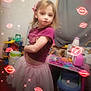 child, girl, indoor, pink_skirt, purple_top, bow, toys, playroom, furniture, table, chair, curtain, face, person, sparkles, lip_overlays, hair, standing, expression, room