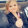 child, car, seat, popsicle, smile, sparkles, magic_effect, window, jacket, hair, face, happy, indoors, portrait, cute, young, holding, hand, seatbelt, light