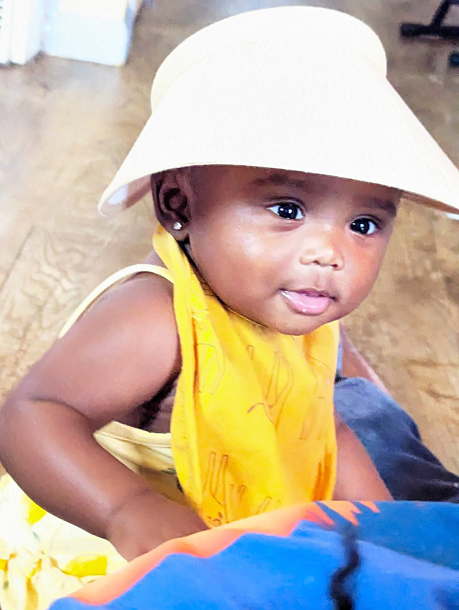 Campbell is registered to the contest to win money with this photo: baby, baby_toddler_clothing, cap, child, chin, eye, face, facial_expression, fashion_accessory, fun, happy, hat, head, headgear, headwear, human, leisure, person, sitting, skin