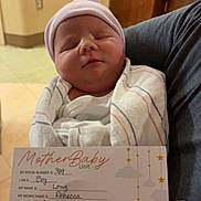 Lucas is registered to the contest to win money with this photo: newborn, baby, infant, hospital, blanket, hat, person, card, text, birth, medical, indoor, holding, sleeping, wrapped, clothing, human, portrait, cute, child