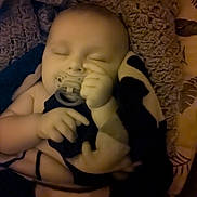 Jordan is registered to the contest to win money with this photo: baby, sleeping, pacifier, blanket, plush_toy, child, infant, cozy, soft, hand, face, rest, comfort, indoors, quiet, peaceful, closeup, cushion, warm_lighting, portrait