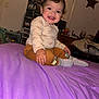 Jeremiah is registered to the contest to win money with this photo: toddler, child, smiling, pajamas, socks, bed, bedspread, purple, room, furniture, drawer, toy, wall_decoration, star, face, hand, hair, indoor, person, happy