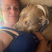 Blue joined the competition — help win amazing prizes! woman, dog, indoor, couch, snuggling, pet, closeup, casual, happy, portrait, relaxing, comfort, brown_dog, tank_top, tattoo, face, human, animal, resting, affection