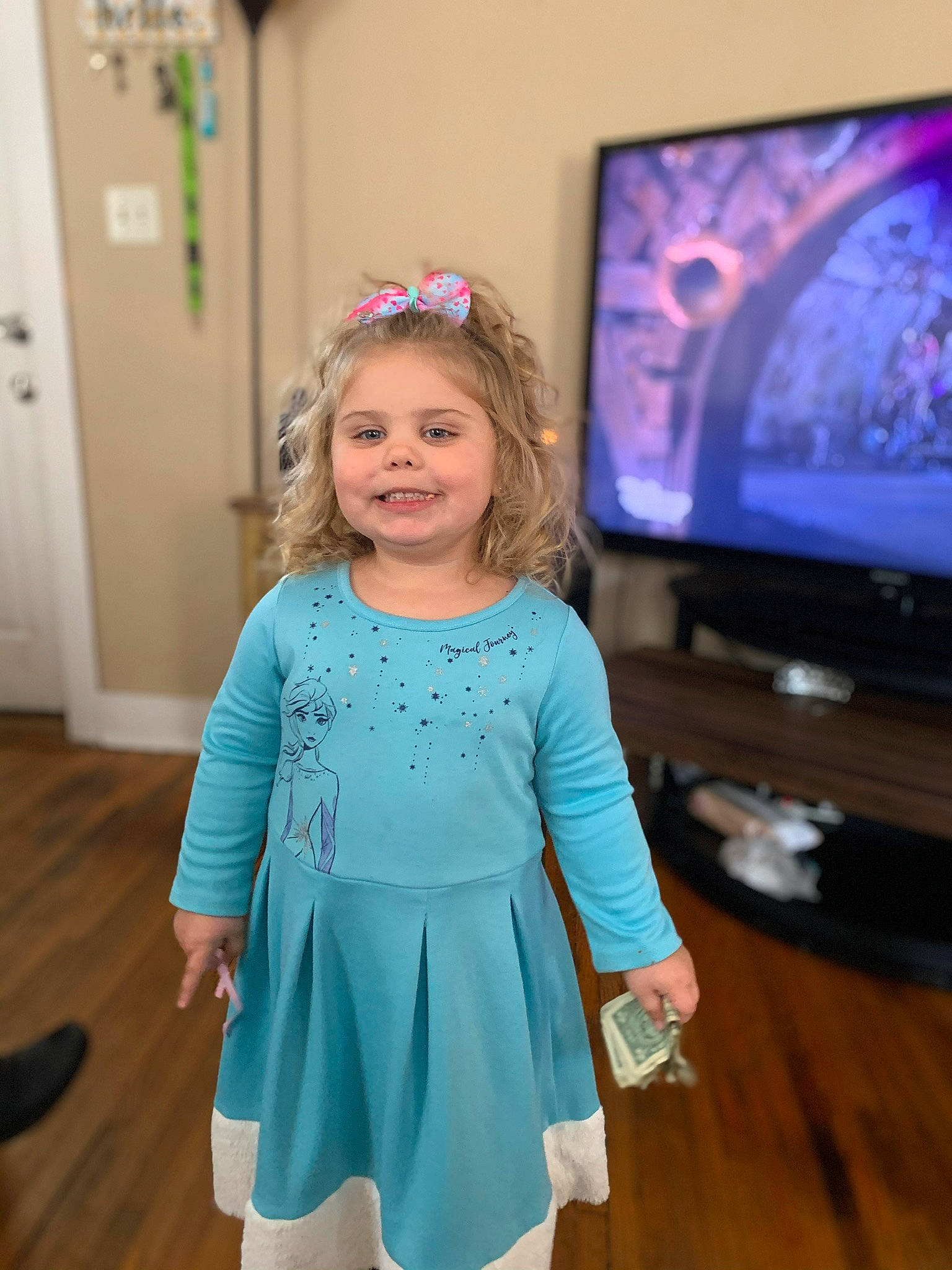 Camryn is registered to the contest to win money with this photo: blue, child, child_model, dress, electronic_device, fun, joy, media, person, photography, purple, sleeve, smile, t_shirt, technology, toddler, turquoise