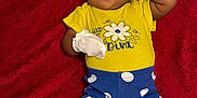 Nalani is registered to the contest to win money with this photo: applique, baby, blanket, bodypart, clothing, couch, face, finger, furniture, glove, hand, happy, head, pajamas, pants, person, photography, portrait, smile, t_shirt