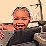 toddler, child, smiling, braids, pink_beads, playpen, hands, face, happy, indoors, baby, portrait, cute, cheerful, skin, person, young_child, furniture, home, closeup