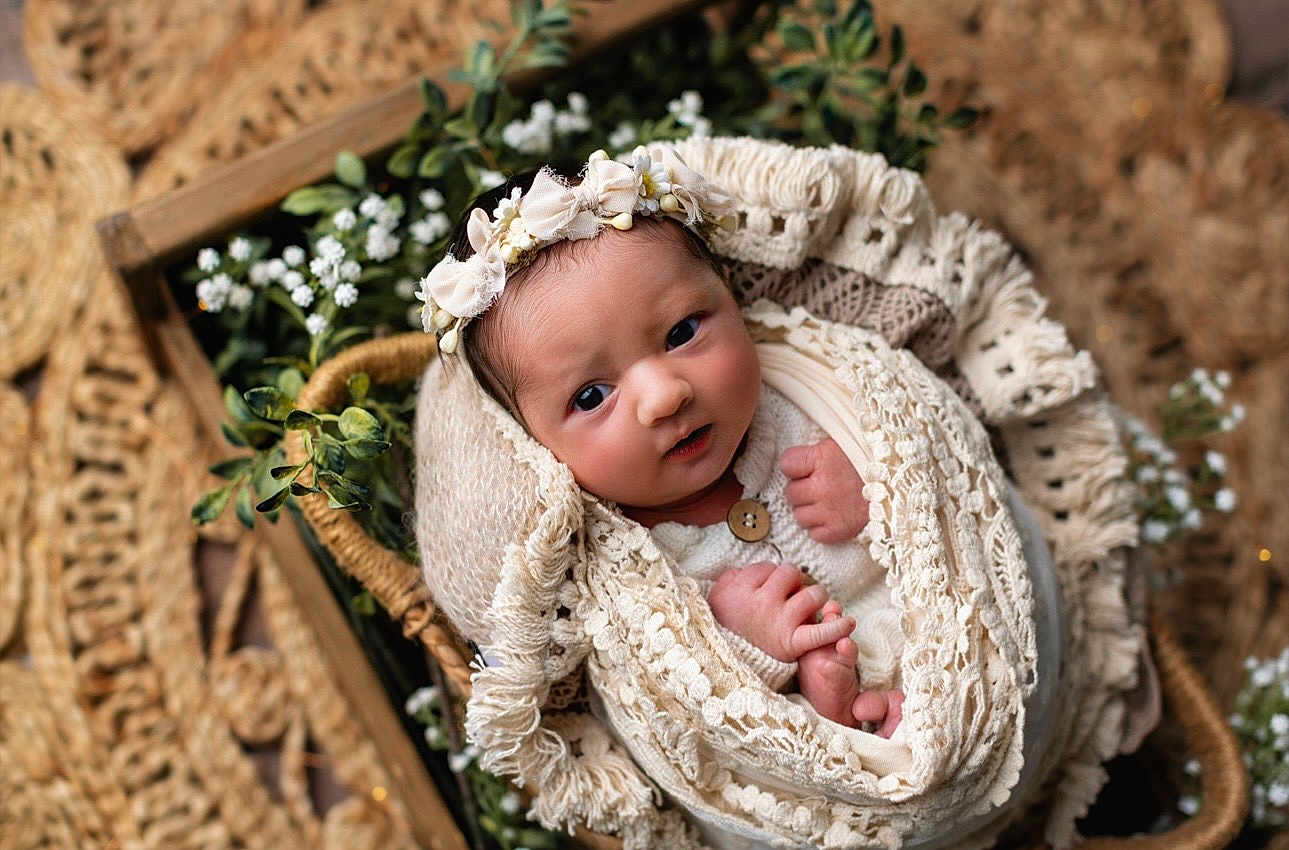 Brielle is registered to the contest to win money with this photo: newborn, baby, infant, blanket, basket, flower_crown, headband, knitwear, portrait, cute, soft_lighting, greenery, woven_texture, natural, cozy, hands, face, wrapped, indoor, decor