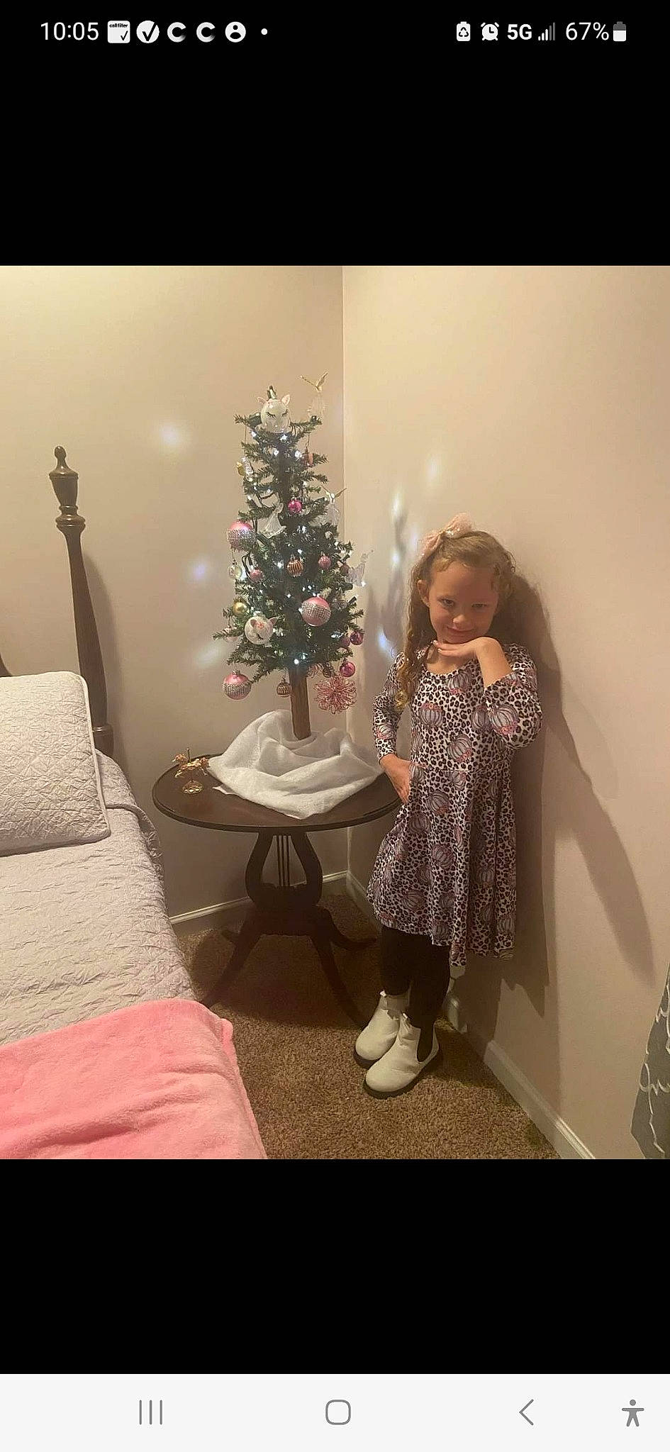 Dezeray is registered to the contest to win money with this photo: christmas, christmas_decoration, christmas_ornament, christmas_tree, conifer, drawer, event, evergreen, holiday, holiday_ornament, joy, living_room, ornament, person, pink, plant, room, smile, table, toddler