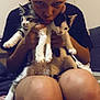 person, cat, kitten, indoor, blanket, couch, knees, holding, cute, pet, feline, animal, face, hands, young_adult, casual, resting, cozy, curious, puckering
