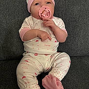 Bellamy joined the competition — help win amazing prizes! baby, pacifier, pajamas, infant, child, sitting, couch, fabric, clothing, hand, footwear, headwear, face, pink, white, pattern, indoor, cute, portrait, cozy