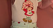 Bellamy joined the competition — help win amazing prizes! baby, infant, child, smiling, tongue_out, headband, flower_headband, cute_clothing, strawberry_pattern, white_shirt, patterned_pants, lying_down, pink_background, happy, playful, small_arms, small_hands, soft_texture, indoors, portrait