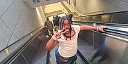 Alihya participe au concours pour gagner de l'argent avec cette photo : child, girl, escalator, peace_sign, braided_hair, glasses, subway_station, people, stairs, green_shoes, white_shirt, denim_skirt, handrail, public_transport, urban, smile, casual_clothing, indoor, portrait, happy