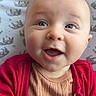 Silas joined the competition — help win amazing prizes! baby, infant, smiling, blue_eyes, red_cardigan, beige_top, blanket, elephant_pattern, close_up, portrait, cute, happy, child, person, skin, face, mouth_open, clothing, indoors, young