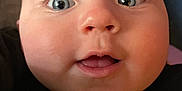 Jameson is registered to the contest to win money with this photo: baby, face, close_up, blue_eyes, expression, chubby_cheeks, innocence, curiosity, portrait, skin, mouth, eyelashes, person, child, head, black_clothing, indoors, cute, human, young