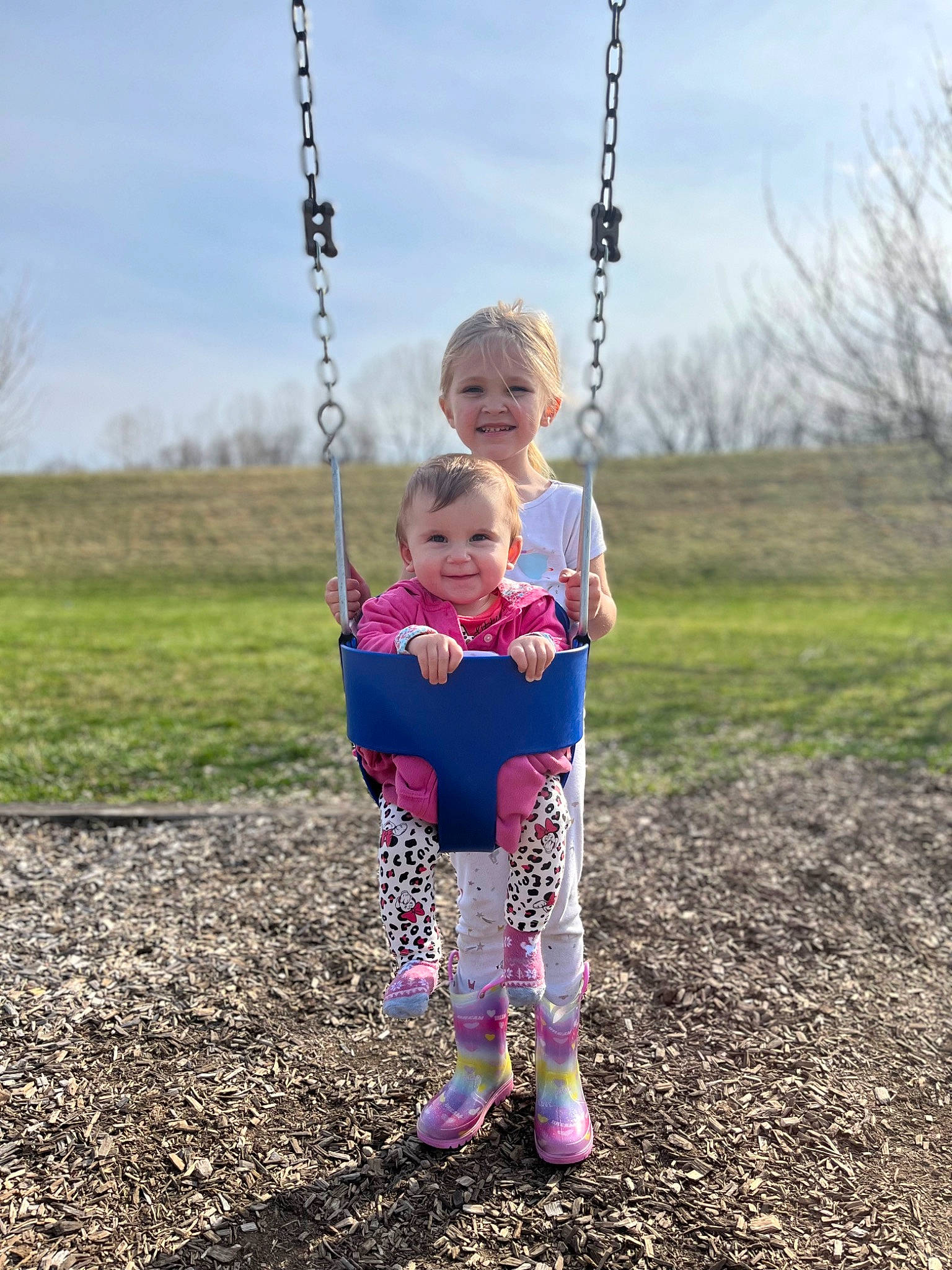Haileigh joined the competition — help win amazing prizes! cloud, face, fun, gesture, grass, happy, head, human_body, jeans, joy, natural_environment, people_in_nature, person, plant, playground, sky, smile, standing, swing, toddler