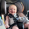 baby, car_seat, child, smiling, toy, dinosaur, bottle, seatbelt, infant, happy, clothing, indoor, person, cute, head, face, sitting, childhood, playful, young