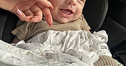 Danny is registered to the contest to win money with this photo: baby, smiling, car_seat, blanket, hand, infant, child, comfort, happy, cute, portrait, clothing, person, seat, car_interior, young_child, expression, wrapped, cozy, touch