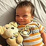 baby, infant, smile, plush_toy, stuffed_animal, bed, onesie, striped_clothing, child, cute, happy, indoors, person, face, head, lying_down, pacifier, soft_toy, toy, cozy