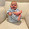 baby, child, infant, smile, happy, pajamas, blue, feet, hand, face, armchair, furniture, cozy, indoor, cute, sitting, skin, head, expression, comfort