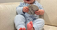 Jackson is registered to the contest to win money with this photo: baby, barefoot, child, couch, cozy, cute, furniture, happy, indoors, infant, milestone_sign, pajamas, person, portrait, seven_months, sitting, smiling, soft_texture, striped_clothing, wooden_sign