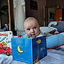 Raphaël a rejoint le concours — aidez-le/la à gagner de superbes lots ! baby, child, bed, book, reading, pillow, room, furniture, toy, curious, indoor, childrens_book, colorful, cozy, smiling, person, head, face, home, soft_lighting