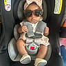 adorable, baby, baby_shoes, bow, car_seat, child, clothing, cute, fashion, footwear, headband, indoors, infant, person, portrait, pucker, safety, seatbelt, straps, sunglasses