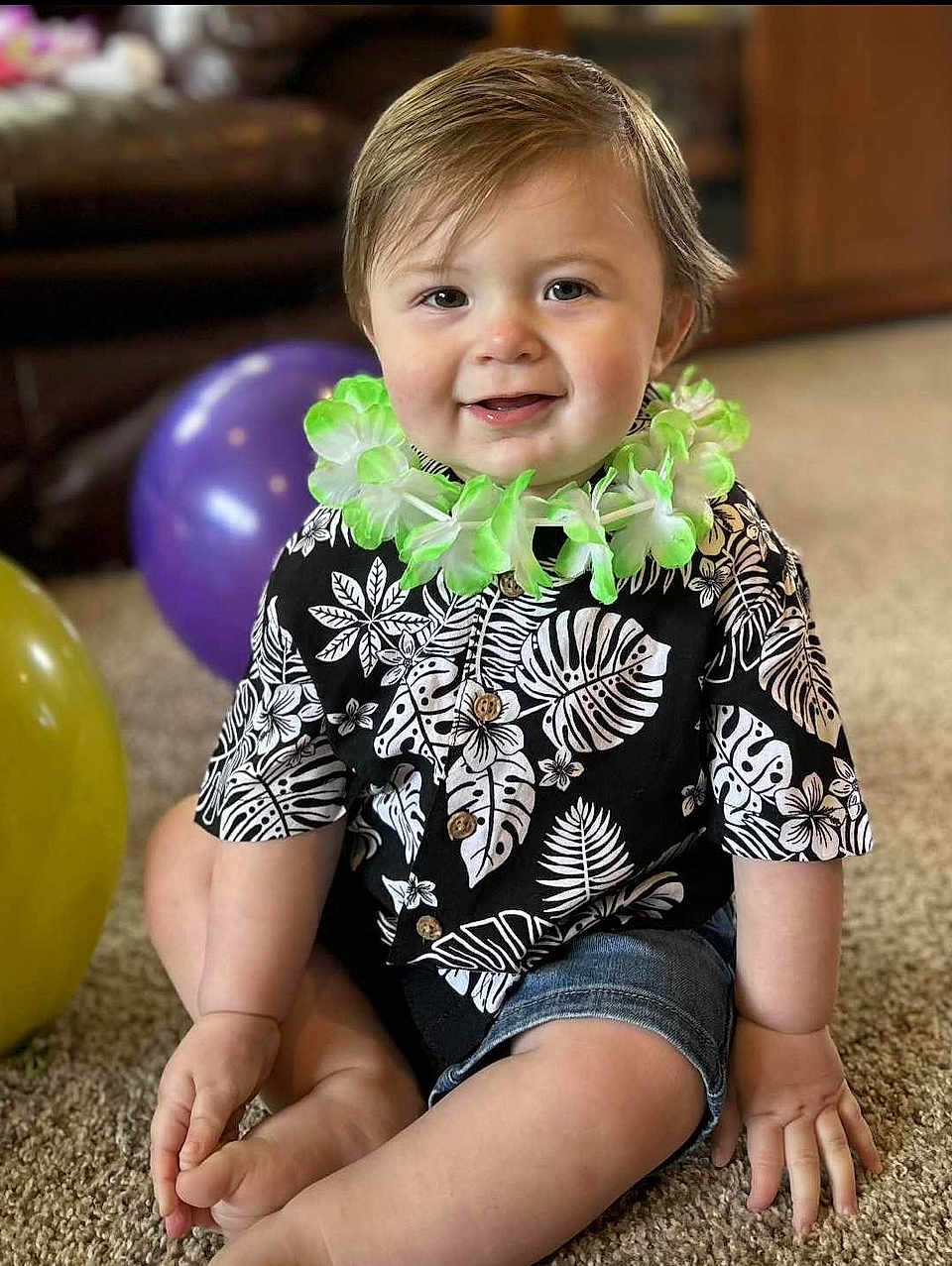 Oli-Ray joined the competition — help win amazing prizes! toddler, child, flower_lei, balloon, carpet, indoor, smiling, shorts, shirt, hands, feet, happy, baby, portrait, candid, sitting, cute, celebration, decor, person