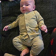 Elias joined the competition — help win amazing prizes! baby, infant, child, pajamas, striped_pants, green_clothing, couch, blanket, pacifier, footwear, indoor, portrait, relaxed, cute, young, person, seated, soft_toys, home, comfort