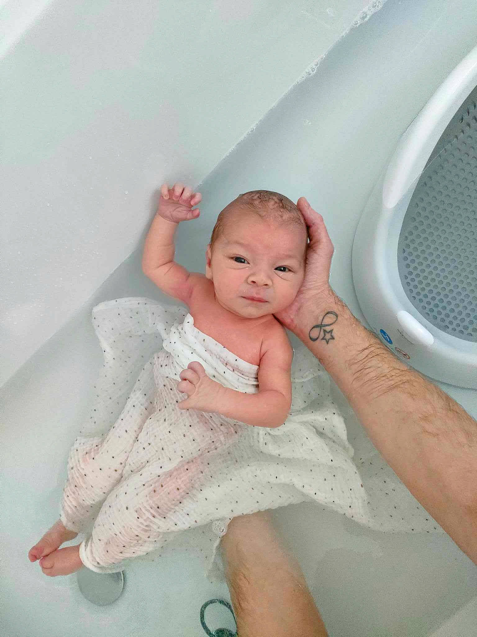 Léandro participe au concours pour gagner de l'argent avec cette photo : baby, baby_toddler_clothing, barefoot, bathing, child, comfort, embellishment, finger, floor, flooring, foot, fun, happy, human_leg, leg, person, pink, skin, thigh, toddler