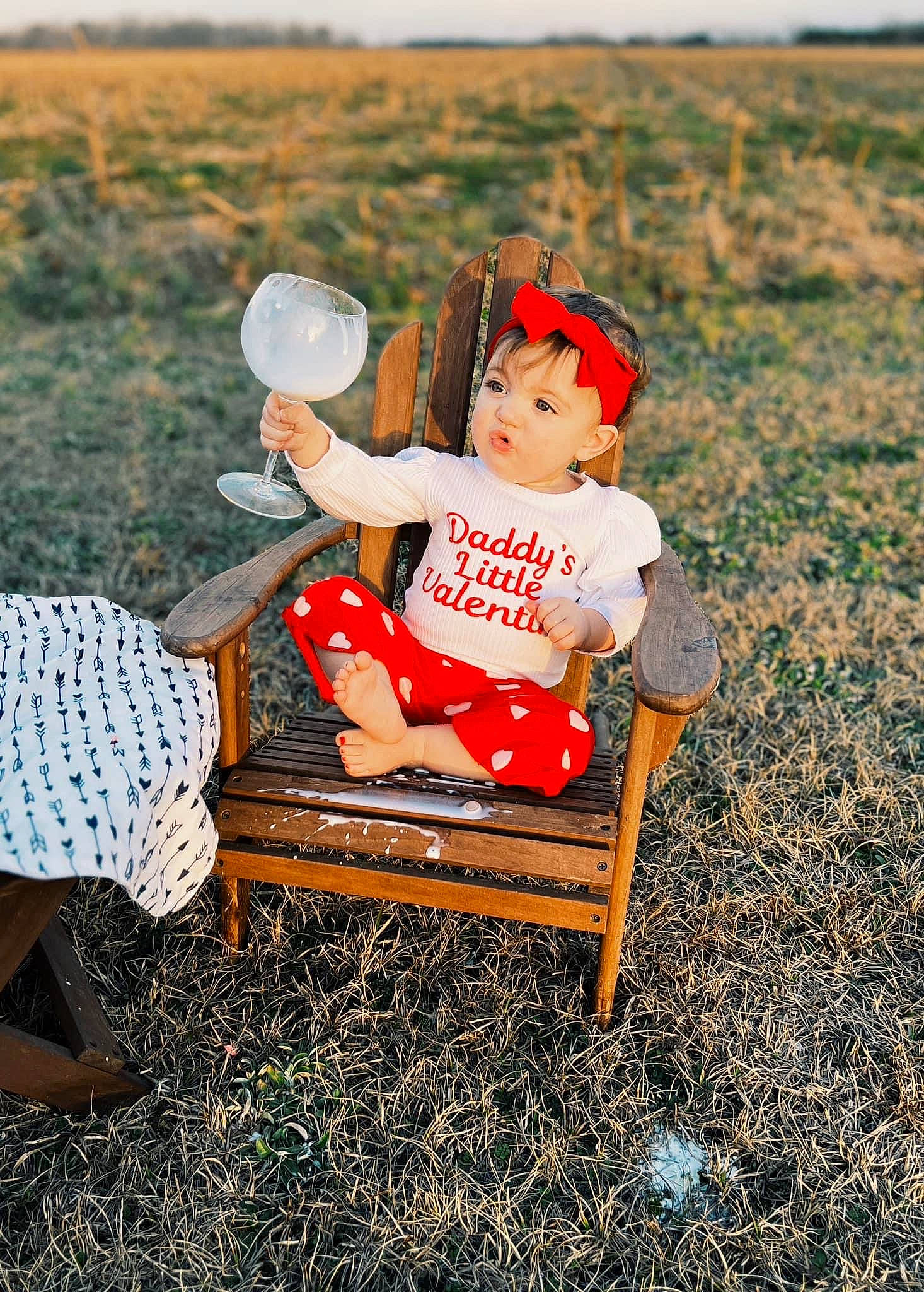 Kendall is registered to the contest to win money with this photo: baby, baby_toddler_clothing, chair, child, field, fun, grass, grassland, happy, hat, landscape, lap, leisure, people_in_nature, person, play, prairie, recreation, sitting, soil