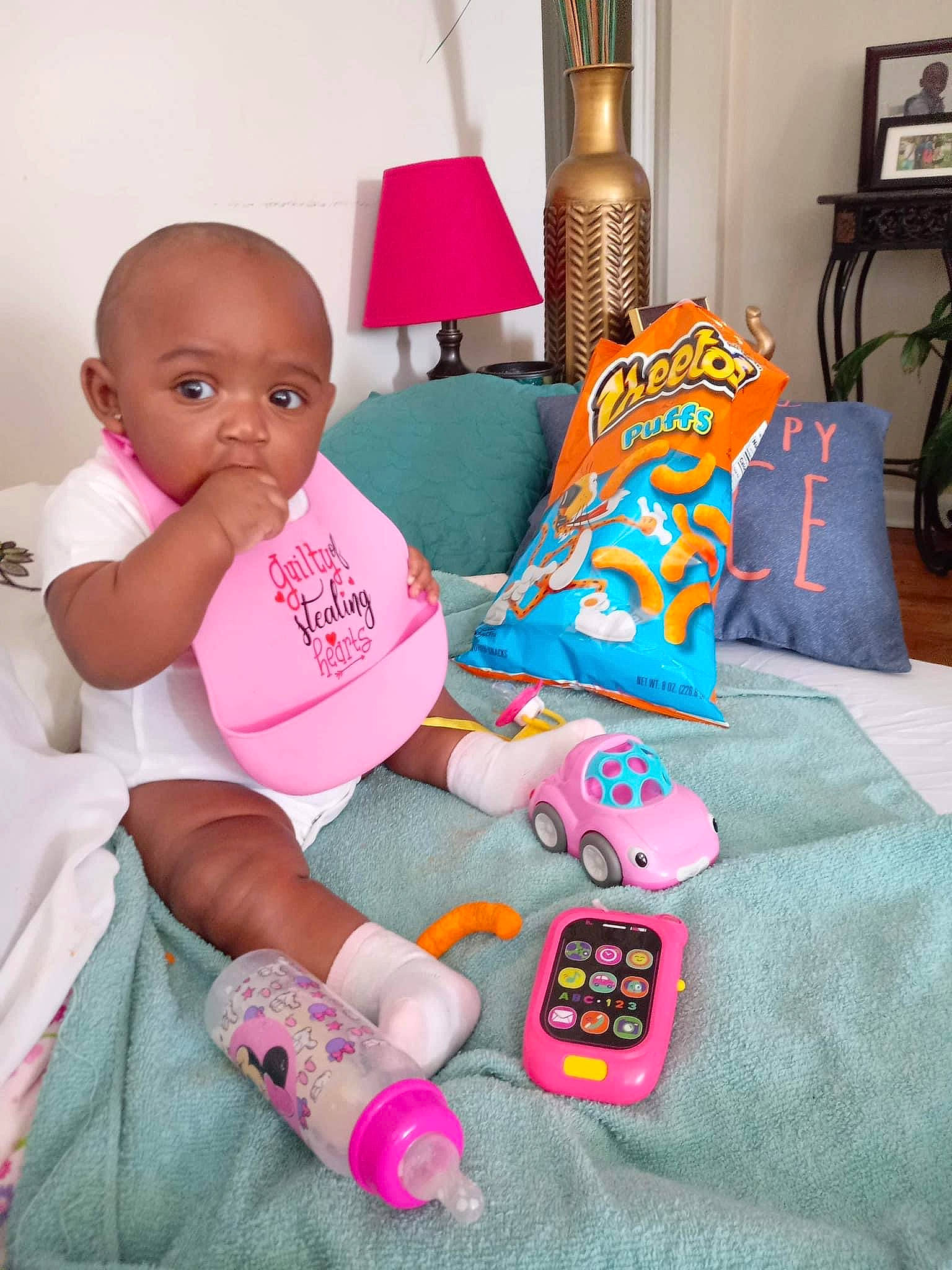 Denavia is registered to the contest to win money with this photo: baby, baby_products, baby_toddler_clothing, bedding, comfort, head, lamp, linens, magenta, pattern, person, picture_frame, pink, play, room, sitting, sock, stuffed_toy, t_shirt, textile