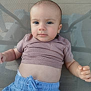Leo participe au concours pour gagner de l'argent avec cette photo : baby, child, face, eyes, shirt, shorts, mesh_chair, hand, skin, expression, casual_clothing, infant, portrait, sitting, indoors, young_child, cute, relaxed, small_person, human