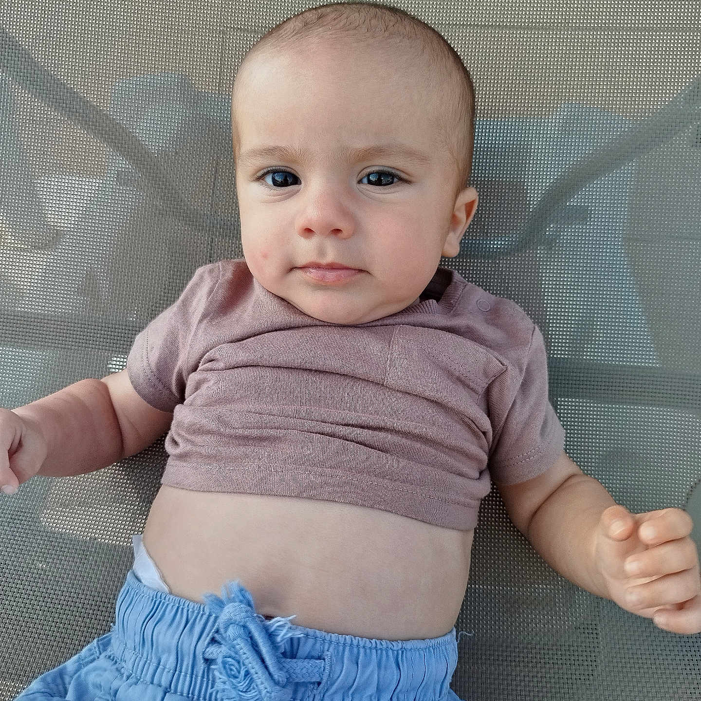 Leo participe au concours pour gagner de l'argent avec cette photo : baby, casual_clothing, child, cute, expression, eyes, face, hand, human, indoors, infant, mesh_chair, portrait, relaxed, shirt, shorts, sitting, skin, small_person, young_child