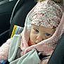 baby, blue_eyes, car_interior, car_seat, child, close_up, cozy, cute, floral_hat, fur_pom_pom, indoor, infant, person, pink_jacket, portrait, seatbelt, soft_fabric, travel, warm, winter_clothes