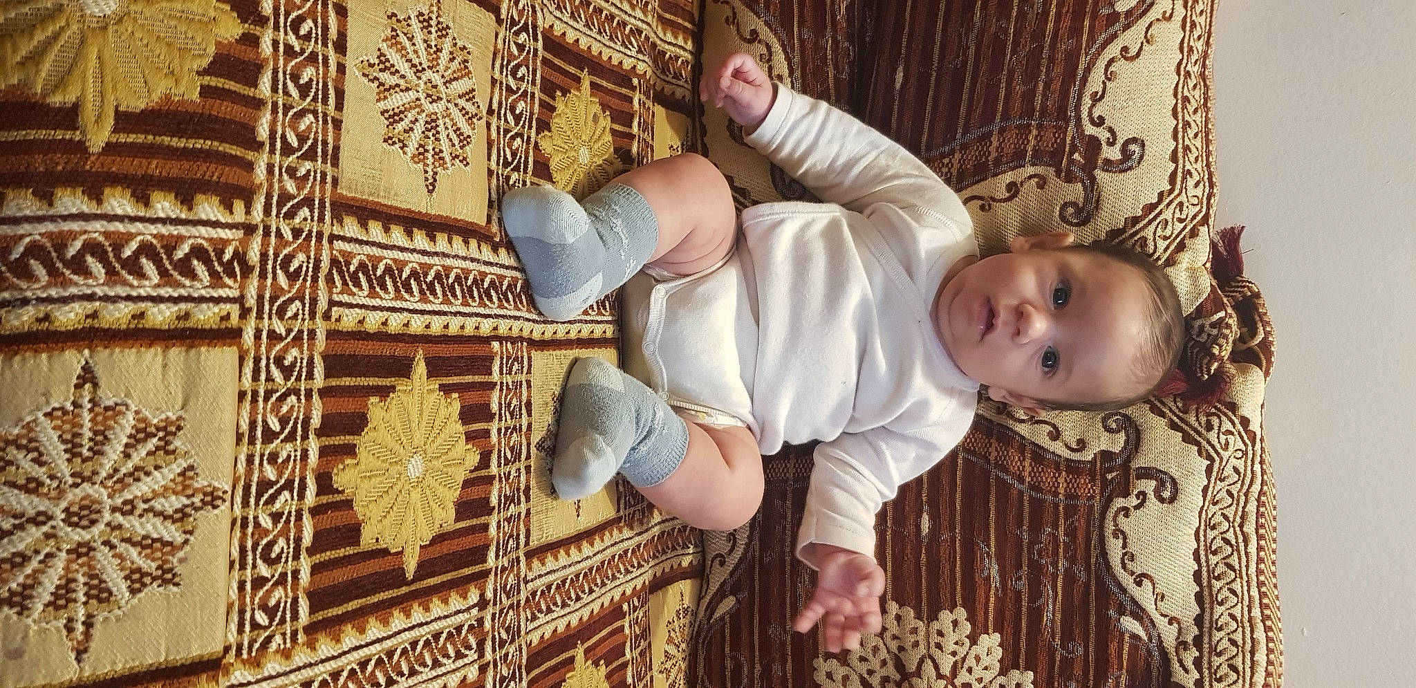 Rayane a rejoint le concours — aidez-le/la à gagner de superbes lots ! baby, baby_products, baby_safety, baby_toddler_clothing, carpet, child, comfort, couch, flooring, foot, human_leg, linens, pattern, person, room, sitting, textile, toddler, visual_arts, wood