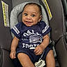 baby, infant, car_seat, smiling, happy, child, clothing, footwear, person, portrait, seatbelt, safety, indoors, cute, young, face, head, fashion, expression, casual