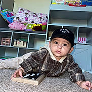 Zeke joined the competition — help win amazing prizes! baby, child, toddler, portrait, indoors, carpet, sitting, lying_down, cap, plaid_shirt, collar, mamas_boy, wooden_board, letters, bookshelf, books, pillows, toys, home, cute