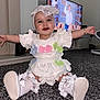 Everli joined the competition — help win amazing prizes! baby, child, indoor, carpet, white_clothing, bows, booties, headband, drool, smiling, happy, person, television, cartoon, furniture, home, floor, sitting, cute, accessories
