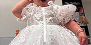 Everli is registered to the contest to win money with this photo: baby, white_dress, lace, bonnet, child, portrait, indoor, cute, adorable, hand, expression, celebration, dress_up, infant, fashion, small_child, person, face, yawn, closeup