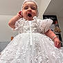 baby, white_dress, lace, bonnet, child, portrait, indoor, cute, adorable, hand, expression, celebration, dress_up, infant, fashion, small_child, person, face, yawn, closeup