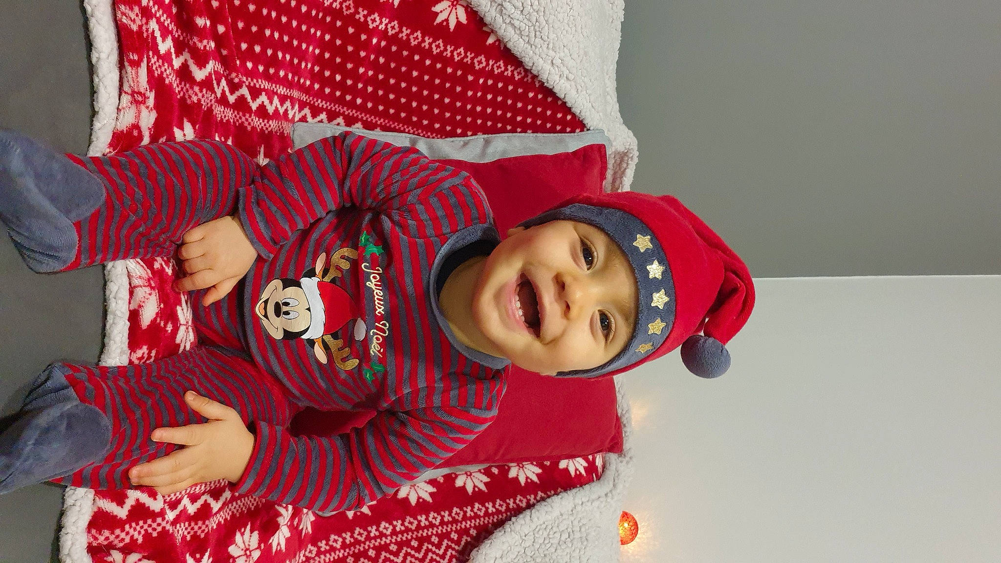 Nolan participe au concours pour gagner de l'argent avec cette photo : baby, baby_toddler_clothing, carmine, child, christmas, christmas_eve, event, facial_expression, fashion_accessory, fictional_character, fun, happy, headwear, holiday, joy, laugh, linens, pattern, person, sleeve